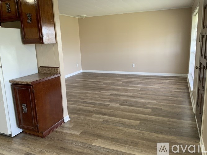 A room with wooden flooring and a cabinet with a marble top.