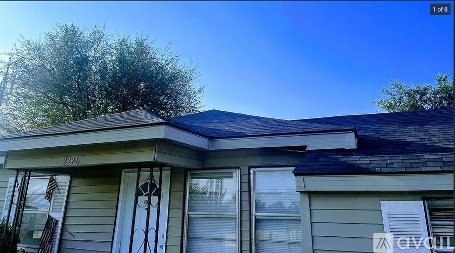 A house numbered 2220 with a flag hanging on the front door.