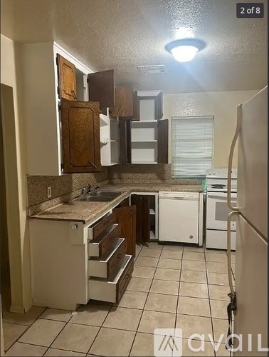 A kitchen with white appliances and brown cabinets.