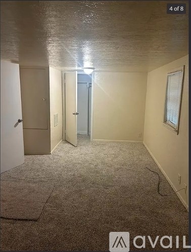A room with a carpeted floor and a door in the middle.