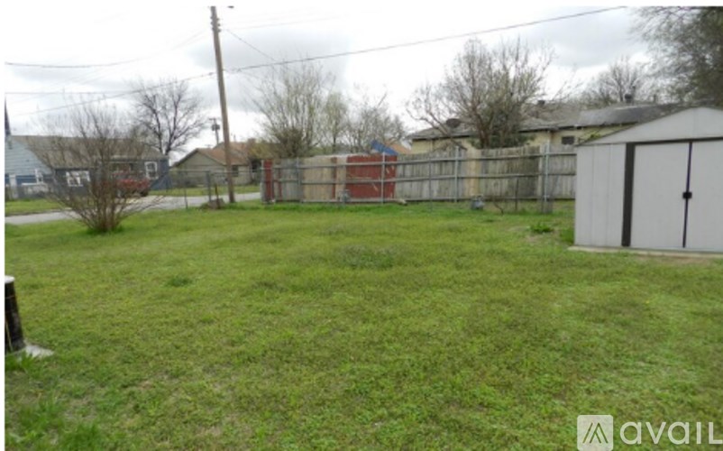 A backyard with a fence and a shed.