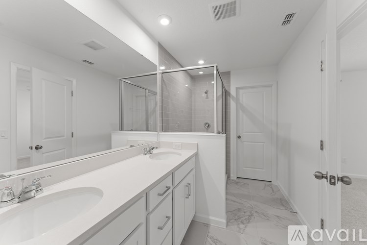 A bathroom with a white sink and a large mirror.