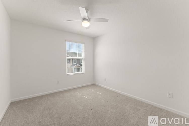 A room with a ceiling fan and a window.