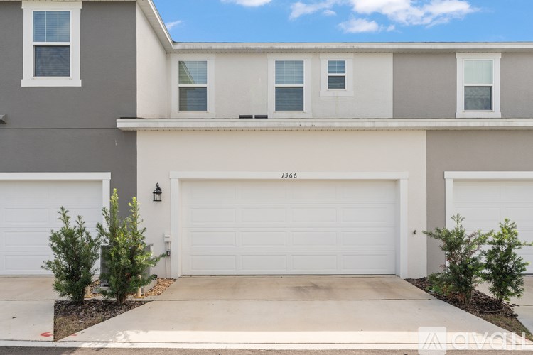 A two-story house with a white garage door and a black mailbox on the front.