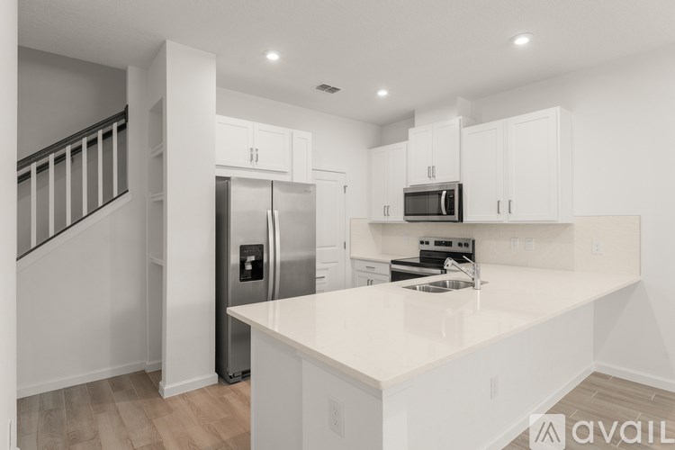 A modern kitchen with white cabinets and appliances.