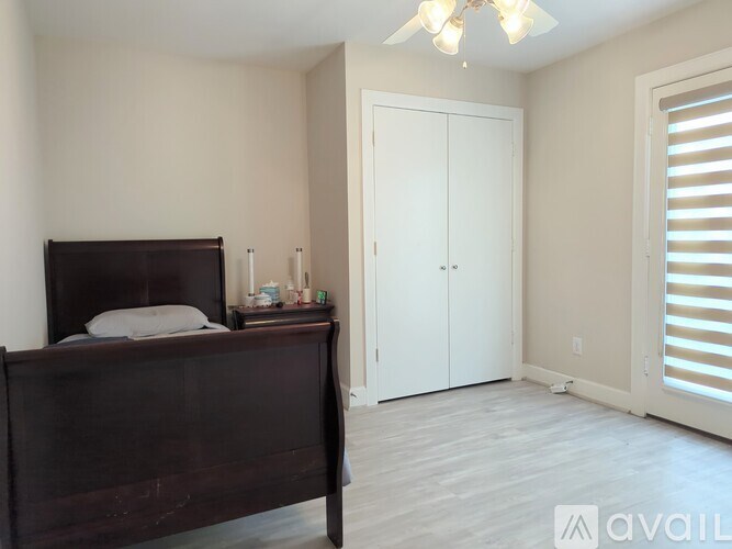A bedroom with a dark brown bed and a white wardrobe.