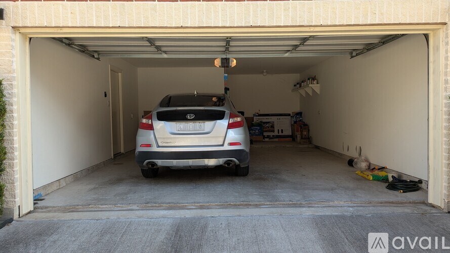 A car is parked in a garage with a light on.