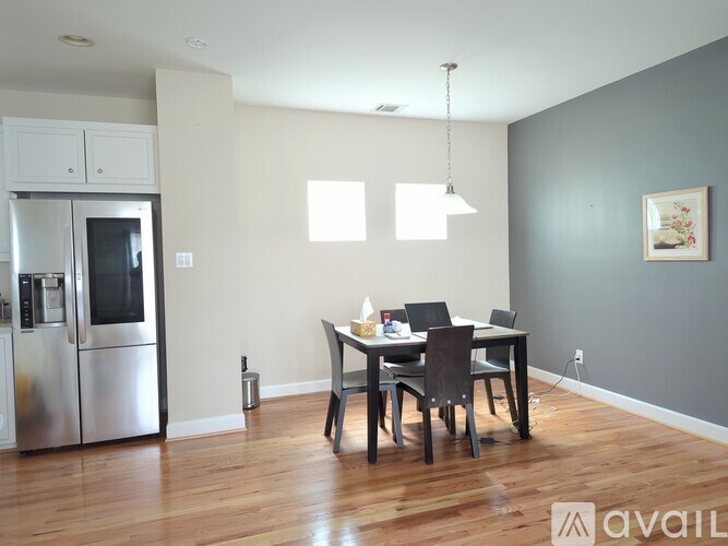 A kitchen with a dining table and chairs in the middle of the room.