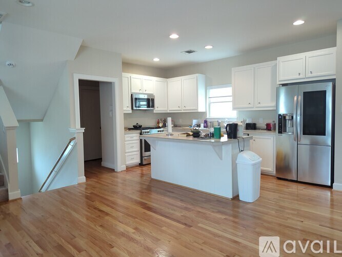 A kitchen with white cabinets and a wooden floor.