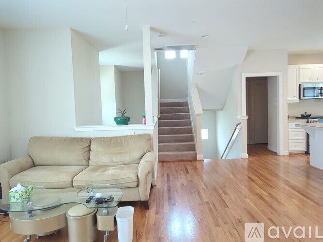 A living room with a beige couch and a glass coffee table.