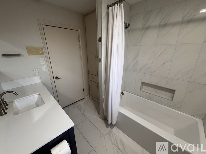 A bathroom with a white sink and a white bathtub.