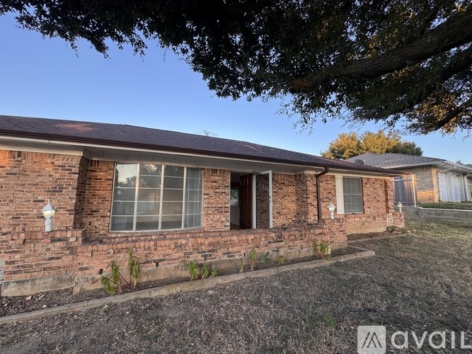A house with a brick facade and a brown roof is shown.
