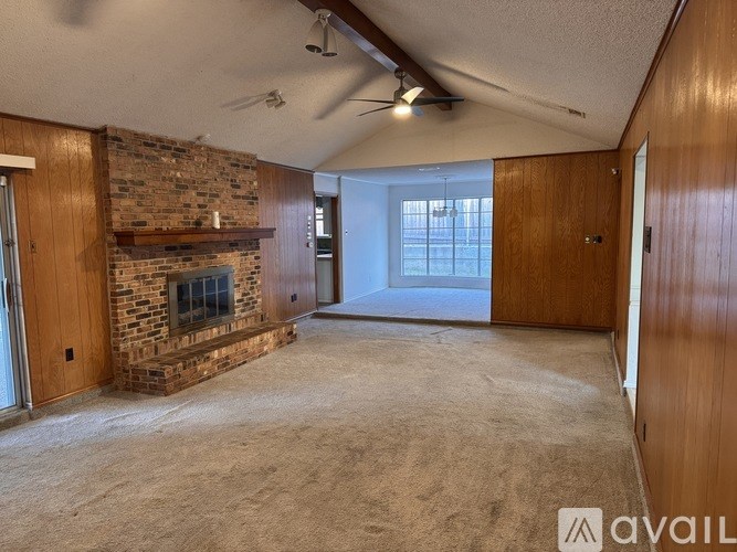 A living room with a fireplace and a ceiling fan.