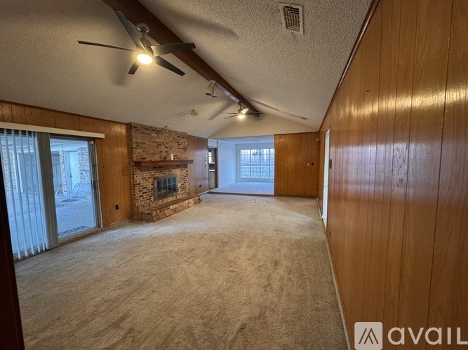 A room with wooden walls and a ceiling fan.