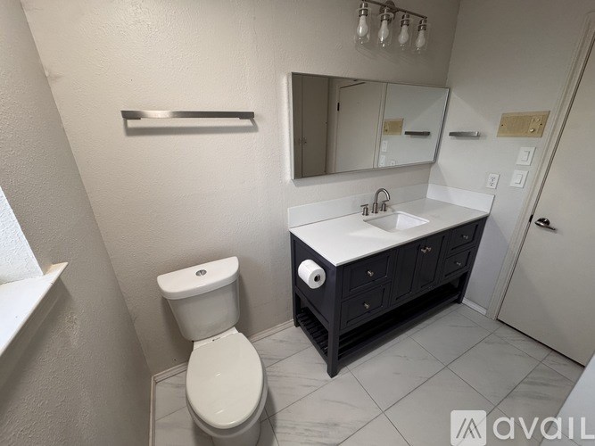 A white toilet is next to a sink in a bathroom.