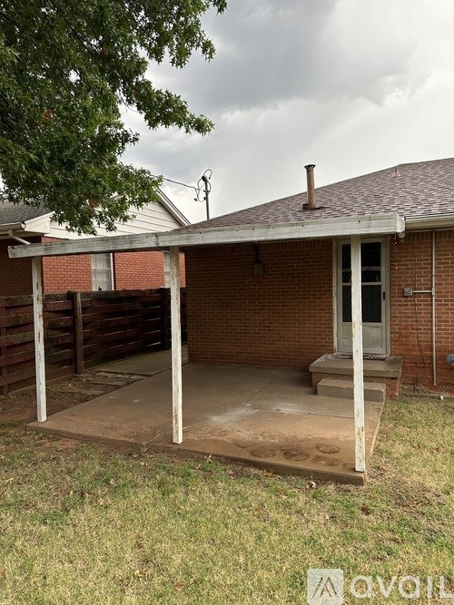 A patio with a brick wall and a door is shown.