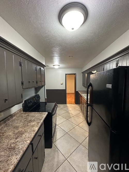 A kitchen with black appliances and granite countertops.