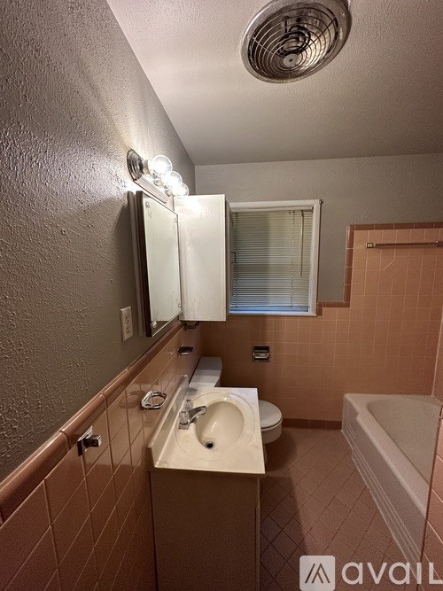 A bathroom with brown tiles and a white sink.