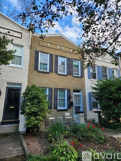 A house with a black door and blue shutters is shown.