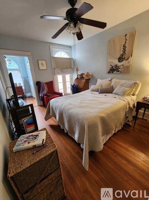 A bedroom with a large bed and a ceiling fan.