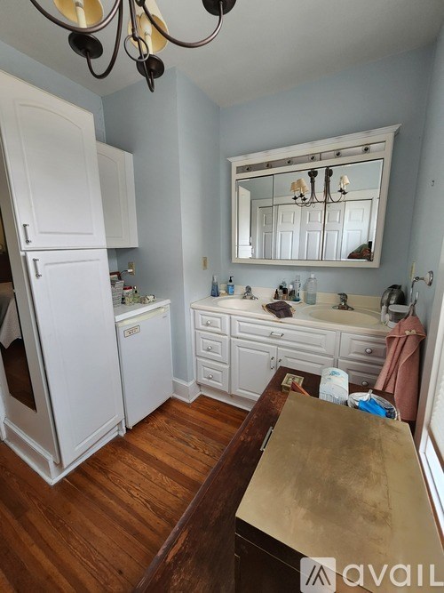 A kitchen with white cabinets and a wooden table.