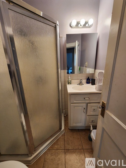 A bathroom with a toilet, sink, and mirror.