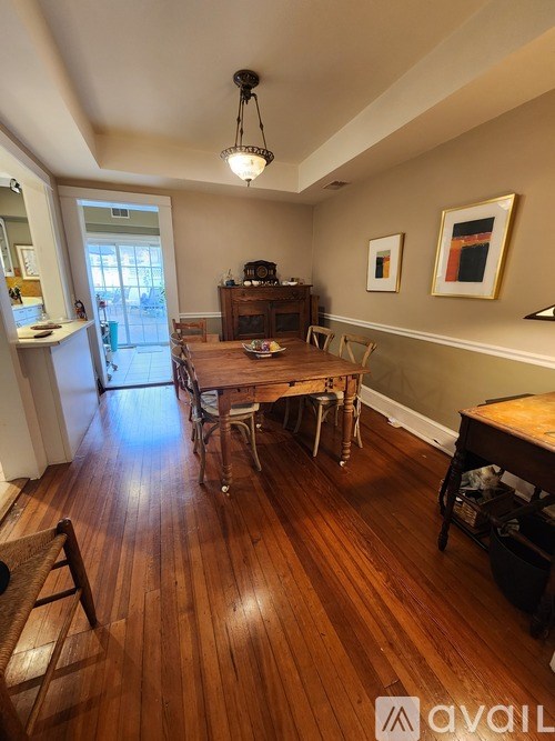 A dining room with a wooden table and chairs.