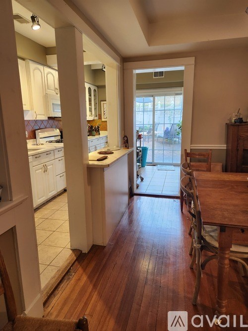 A kitchen with white cabinets and a wooden floor.