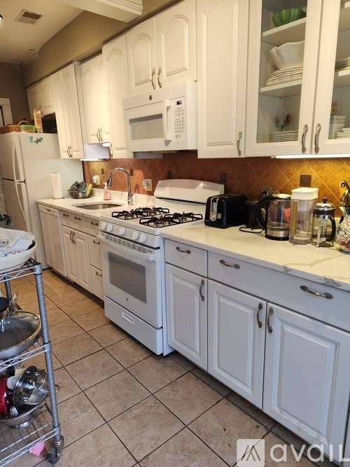A kitchen with white cabinets and appliances.