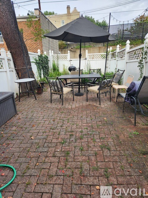 A patio with a table and chairs under an umbrella.