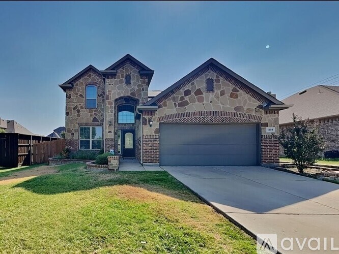 A house with a stone facade and a garage door is for sale.
