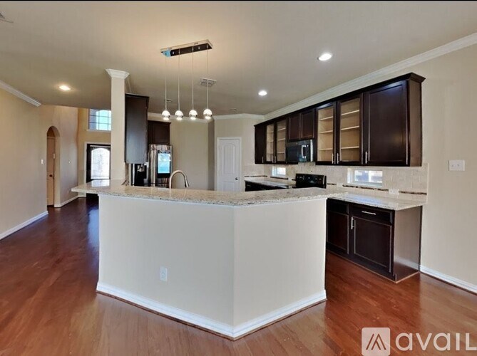 A modern kitchen with dark brown cabinets and a white island.