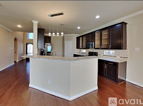 A modern kitchen with dark brown cabinets and a white island.