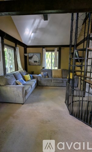 A living room with a couch and a painting on the wall.