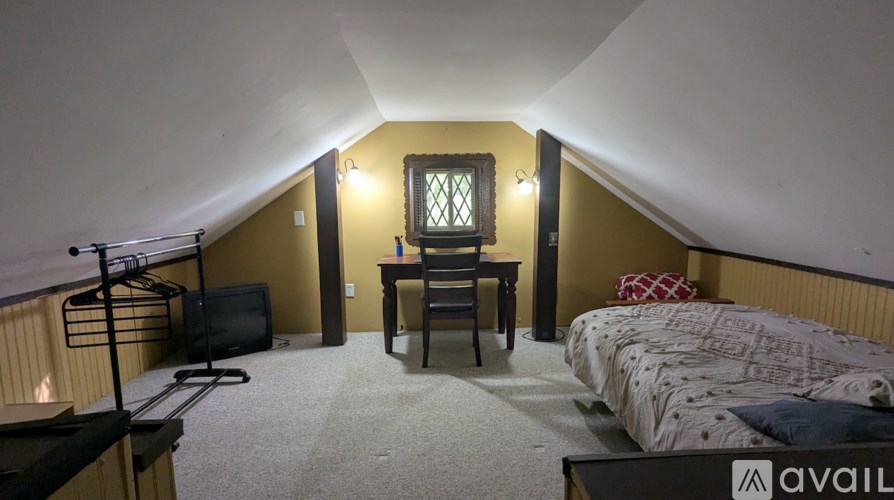 A bedroom with a bed, desk, and chair.
