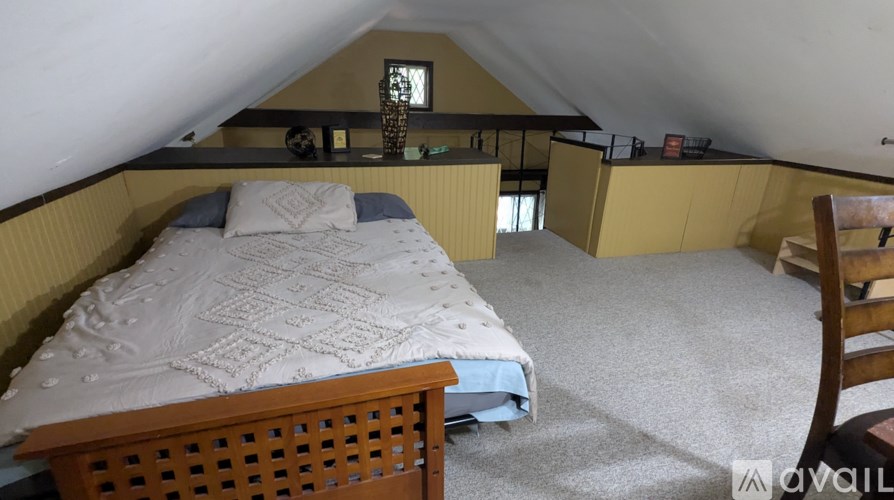 A bedroom with a bed and a chair.