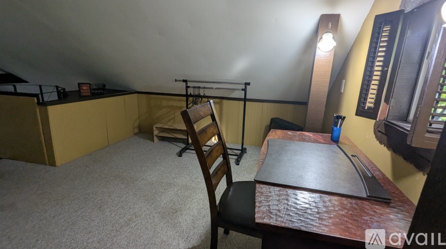 A room with a desk and chair in it.