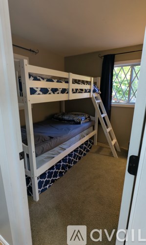 A room with two bunk beds and a ladder.