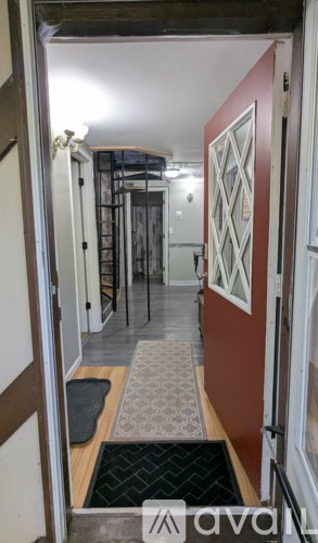 A hallway with a black and white patterned rug on the floor.