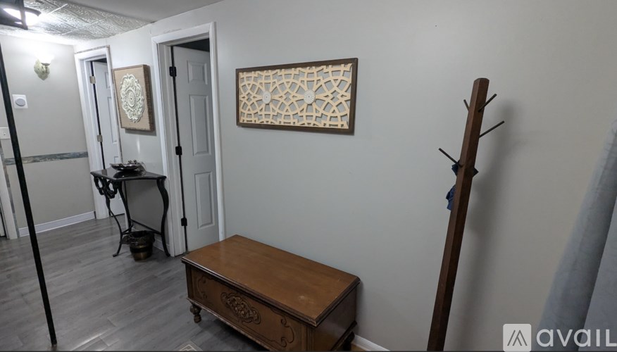 A room with a wooden bench and a painting on the wall.