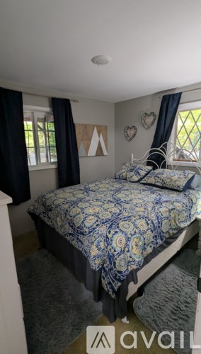 A bedroom with a bed and a window with curtains.