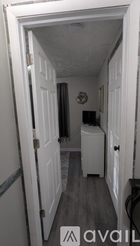A hallway with a white door and a white cabinet.