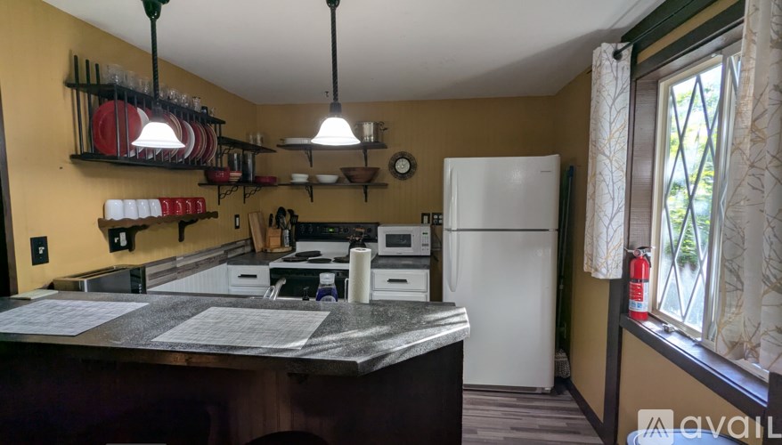 A kitchen with a white fridge and a stove top oven.
