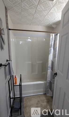 A bathroom with a glass shower door and a white ceiling.