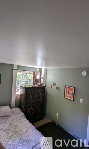 A bedroom with a bed, dresser, and window.