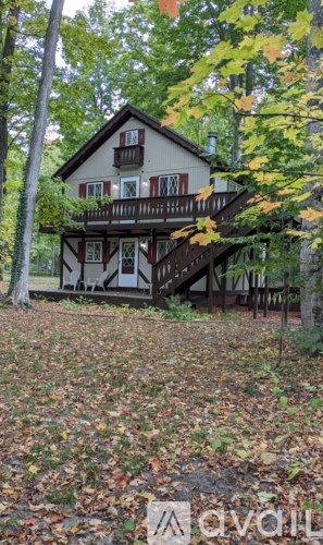 A house with a balcony surrounded by trees.