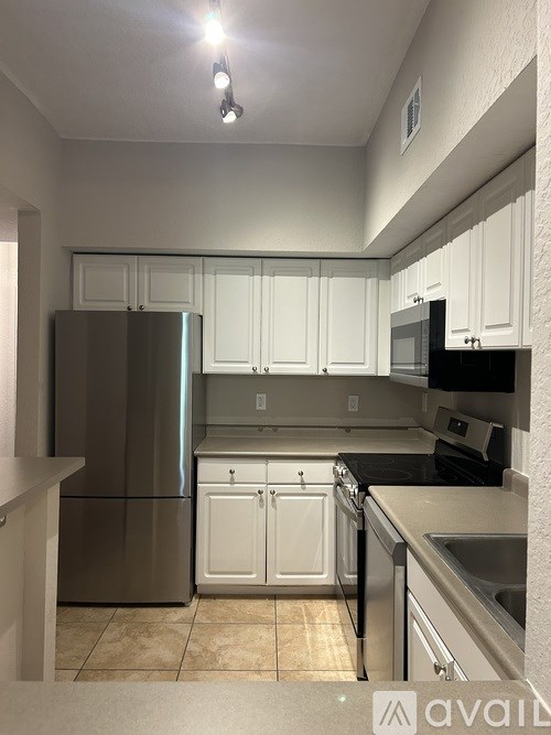 A kitchen with white cabinets and stainless steel appliances.