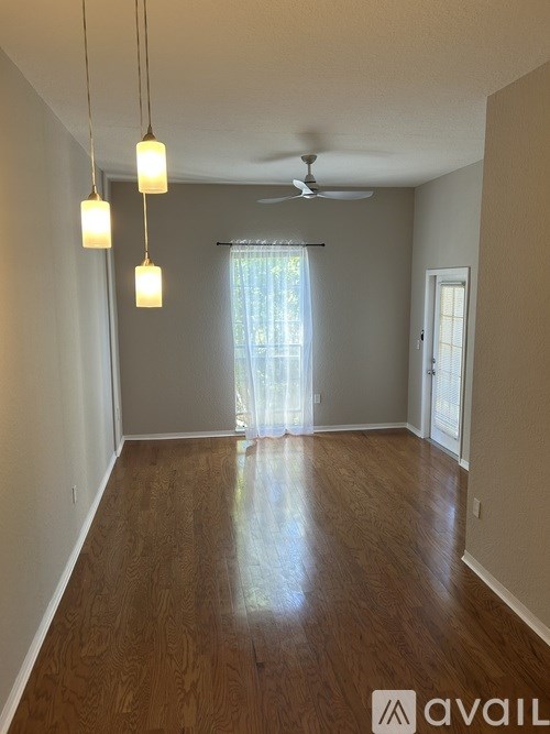 A room with wooden floors and a ceiling fan.
