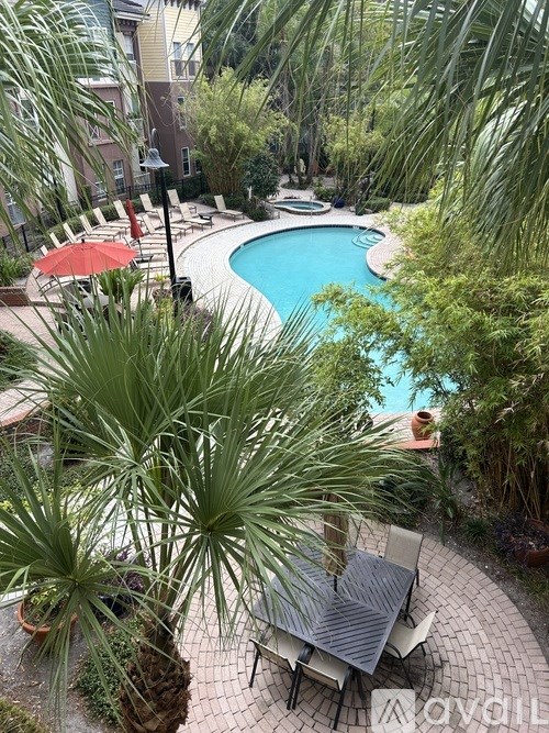 A pool surrounded by green plants and trees.