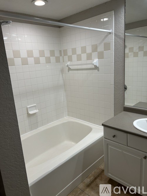 A bathroom with a white tub and a sink.